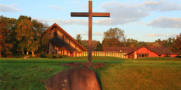 front exterior of Genesee Abbey church, with wooden cross in front