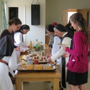 nuns and retreatants in serving line with plates