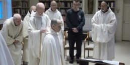 Br. Elijah new novice dressed in white smock prostrate before abbot and monastic community