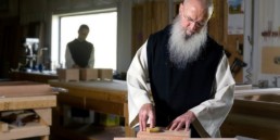 Monks working with wood blocks in carpenter shop