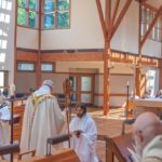 Br. Scott kneels before abbot, clothed in new cowl