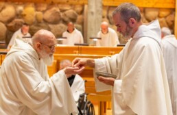 Elderly monk receiving Holy Communion from a Priest-Monk