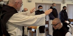 Fr. Paul-Mark raises hands in blessing over Br. Isaac at his first profession of vows.