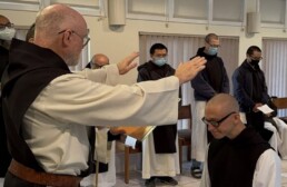 Fr. Paul-Mark raises hands in blessing over Br. Isaac at his first profession of vows.