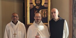 Dom Gerard, Brother Luke and Brother Isaac pose before an icon of Christ Pantocrator