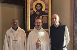 Dom Gerard, Brother Luke and Brother Isaac pose before an icon of Christ Pantocrator