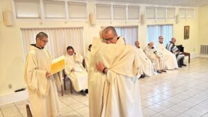 Brother Simon receives a congratulatory hug from Abbot Paul-Mark Schwan after professing first vows as a monk.